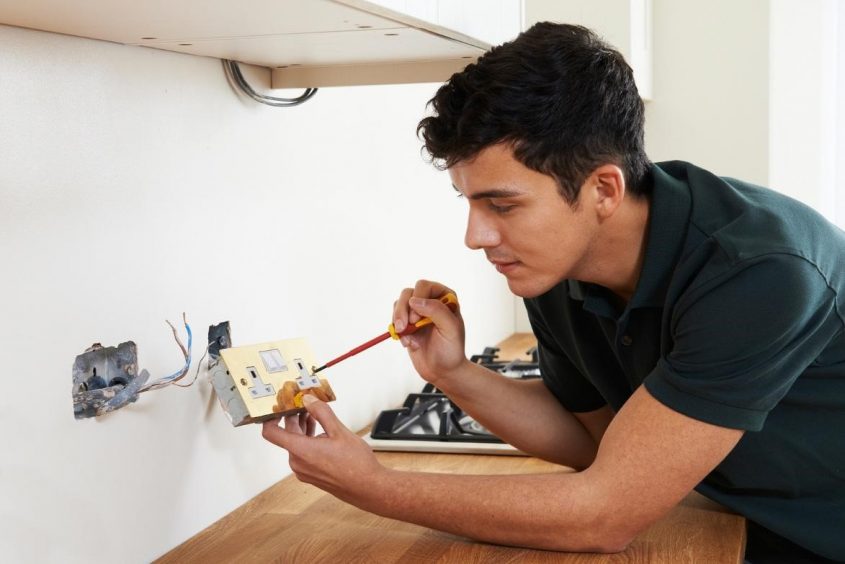 Man fixing electrical outlet